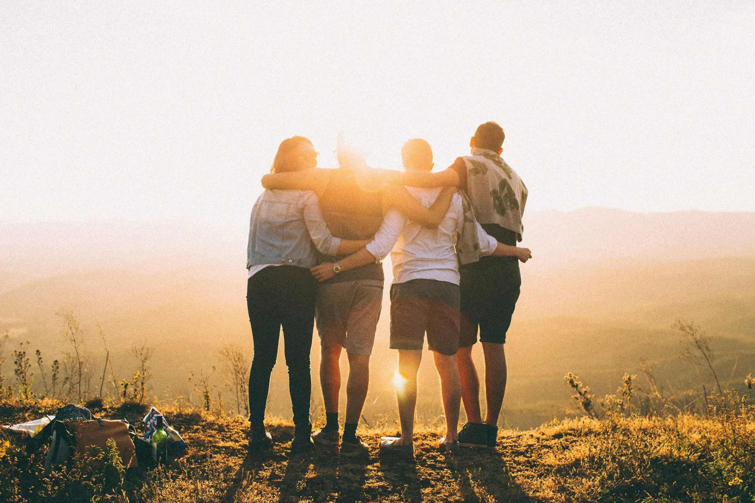 Jovens abraçados olhando o horizonte ao pôr do sol